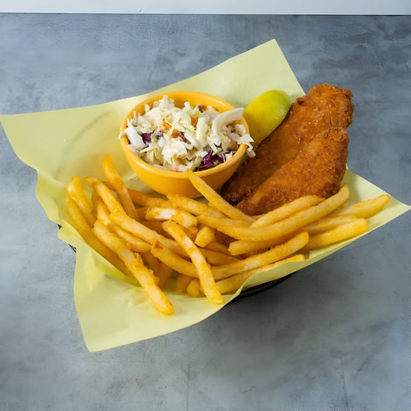 Crispy fried fish, golden french fries, and a side of coleslaw with a lemon wedge.